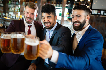 Group of happy friends drinking beer at the pub and having fun