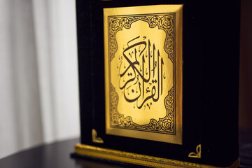 Holy Quran Book  black and golden color. Arabic calligraphy.  Symbol of Islam. 