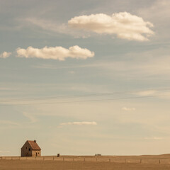 ferme ancienne isolée au milieu d'un vaste champ à la campagne