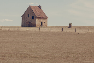 maison abandonnée en pierres au milieu d'un champ aride à cause de la sécheresse