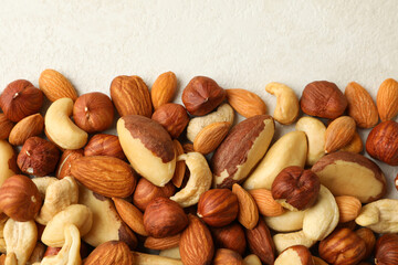 Different nuts on white textured background, space for text