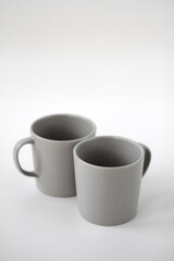 two grey cups in the studio on a white background
