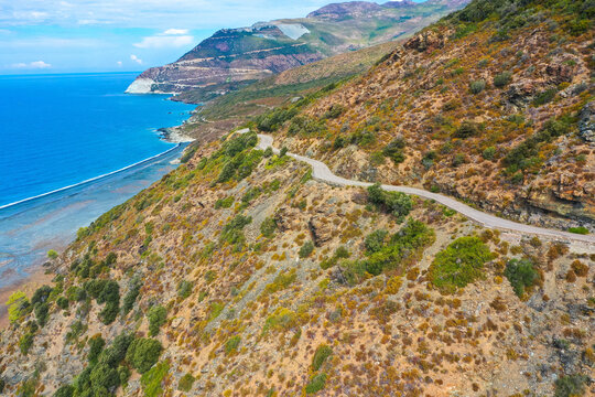 Aerial view of the famous D80 road around Cap Corse peninsula, the important tourist path in Corsica Island. Haute-Corse, France. Tourism and vacations concept