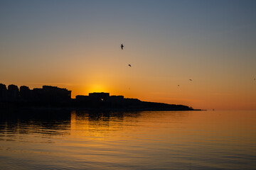 Naklejka premium City on the sea at sunset
