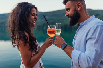 Beautiful couple toasting with wine outdoors