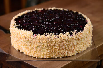 Close up of blueberry creamy pie with almonds on wooden table