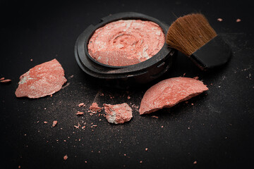 Blush on and brush is broken and scattered on a black background, Broken and cosmetic, cracked and...