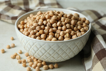 Bowl with chickpea on white textured table with kitchen towel