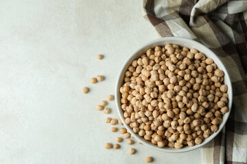 Bowl with chickpea on white textured table with kitchen towel