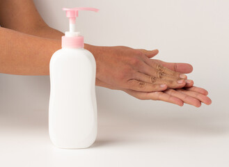 The hand was rubbing the lotion and there was a white lotion bottle pump on the front.