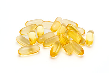 Pile of dietary supplement oil capsules on a white background, softgel capsules.