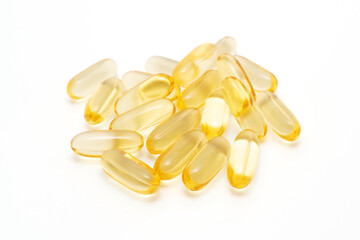Pile of dietary supplement oil capsules on a white background, softgel capsules.