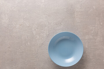 Blue plates on light stone background, top view