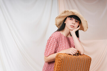 Beautiful asian thai long dark hair woman wearing straw hat and red dress with picnic basket.