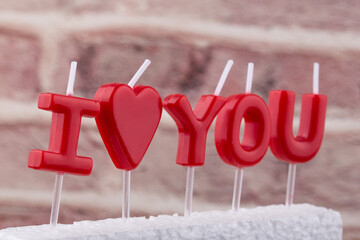 red burning candles making 'I love you' isolated.