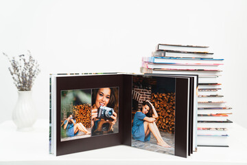 Fototapeta na wymiar stack of books. open photobook from photo shoots of beautiful brunette woman 