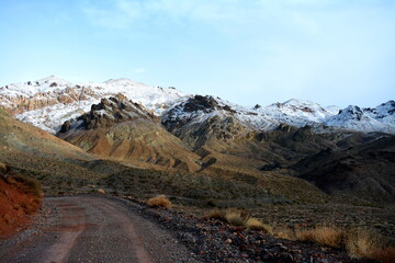Titus Canyon road winding one way from Nevada to California in the Amargosa Mountains, Death Valley National Park on a snowy day in December