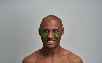 Man with self-assured smile in under eye patches