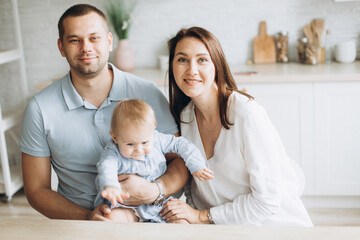 Obraz premium Happy family and infant daughter together at home. Childhood, family concept