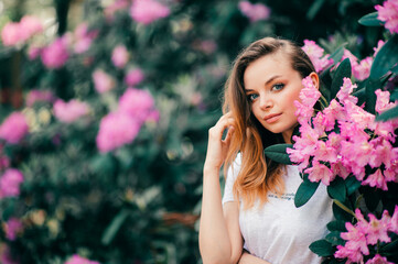 Naklejka premium Young beautiful girl posing among the flowering tree