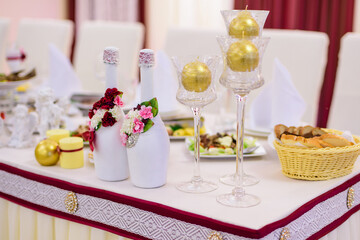 Champagne bottles in white floral decor on a banquette table