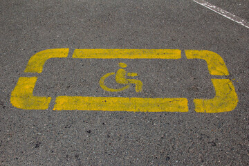 Fototapeta premium Disabled person sign applied to the parking space with yellow paint.