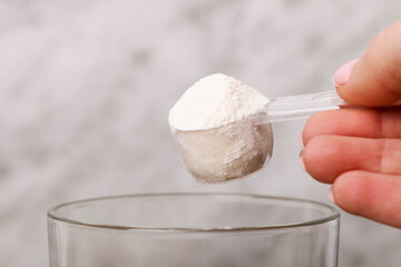 white protein powder in measuring spoon