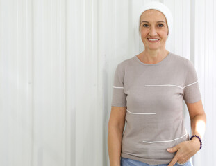 Portrait of middle age woman with clothe cover abound head to hide hair loss from chemotherapy in breast cancer cure process, smiling with strength and hope.