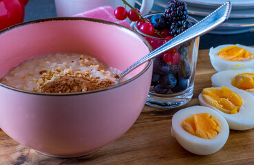 gluten free breakfast  with porridge, berries and fresh boiled eggs