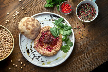 Appetizing French dish - chicken pate with onion jam and pita bread served in a white plate on a wooden background. Close up view
