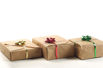 Banner template from gift boxes, covered by brown craft paper, tied by red, yellow and green bows and ribbons on white background isolated with copy space, selective focus