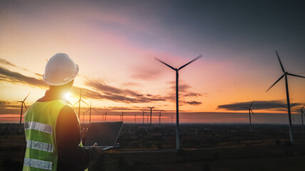 Silhouette of Technician Engineer  at wind turbine electricity industrial in sunset