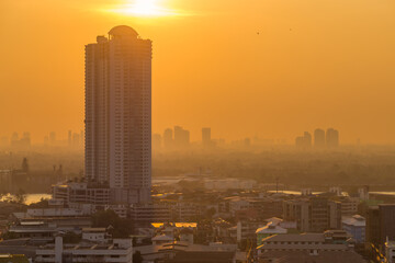 Fototapeta premium The blurred abstract background of the morning sun exposure to the tiny dust particles that surround the tall buildings in the capital, the long-term health issue of pollution
