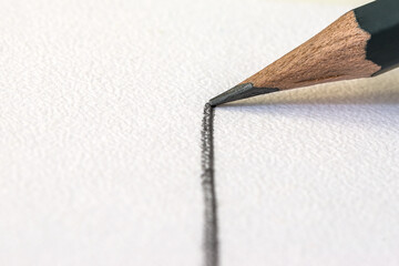 a graphite pencil draws a gray line