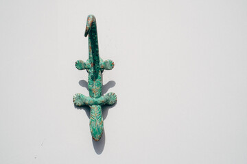 green lizard shaped hook on white wall