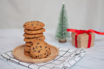 Homemade Chocolate chip cookies on linen napkin and blurred Christmas tree background.