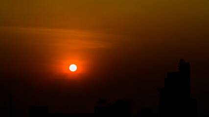 The blurred abstract background of the morning sun exposure to the tiny dust particles that surround the tall buildings in the capital, the long-term health issue of pollution © bangprik
