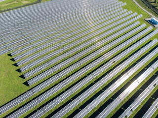 Solar Photovoltaic of aerial view, solar plant rows array of on the grass on the farm. Top view