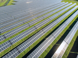 Long Solar panels in a field in a row. View from the drone. Huge Solar panels under the sun. Solar concept