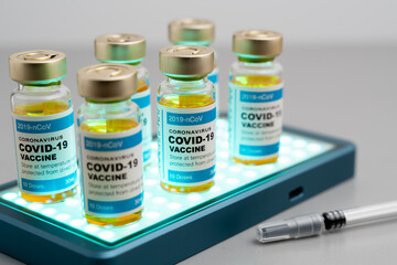 ampoules or vials with Covid-19 vaccine on a laboratory bench. SARS-CoV-2 Vaccination, immunization, treatment to cure Covid 19 Corona Virus infection. Medical concept.