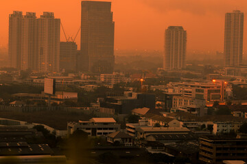 Obraz premium The high angle background of the city view with the secret light of the evening, blurring of night lights, showing the distribution of condominiums, dense homes in the capital community