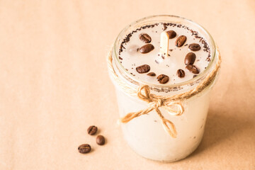 DIY concept. Handmade scented candle with coffee beans in a glass jar with copy space.