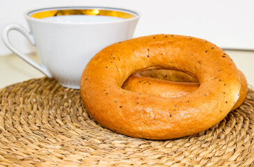 Bagels with poppy seeds with a white mug in the background.
