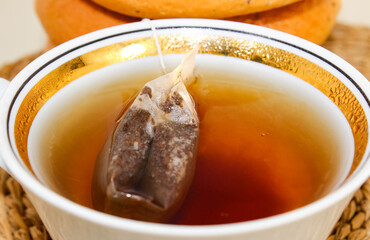 A cup with a tea bag filled with boiling water.