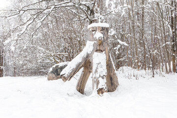 An old stump in the form of a man under the snow. Close-up