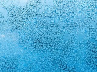 Ice patterns on frozen window - blue winter background