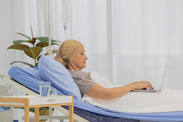 A middle-aged breast cancer patient lay on bed and still working with notebook computer