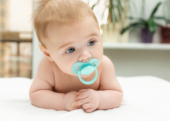Close-up portrait of a little baby boy with pacifier on mouth. Charming grey-eyed baby boy 3 month...