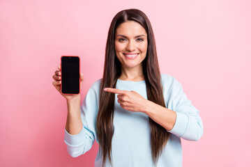 Photo portrait of brunette pointing finger mobile phone display blank pace isolated on pastel pink color background