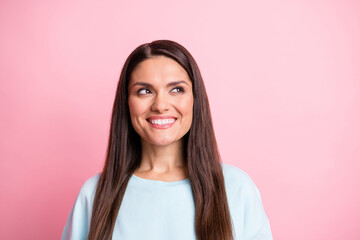 Photo portrait of cheerful woman looking blank space curious smiling isolated on pastel pink color background